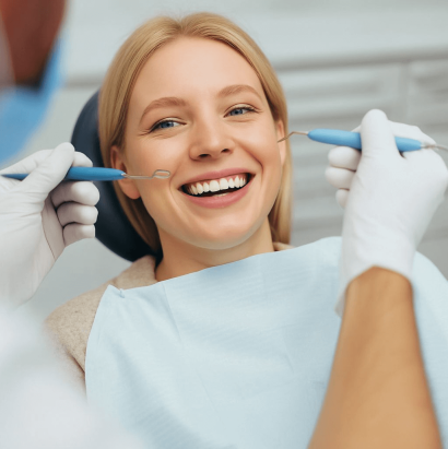 Smiling Blonde Woman in Dental Chair Amid Bright Clinical Setting